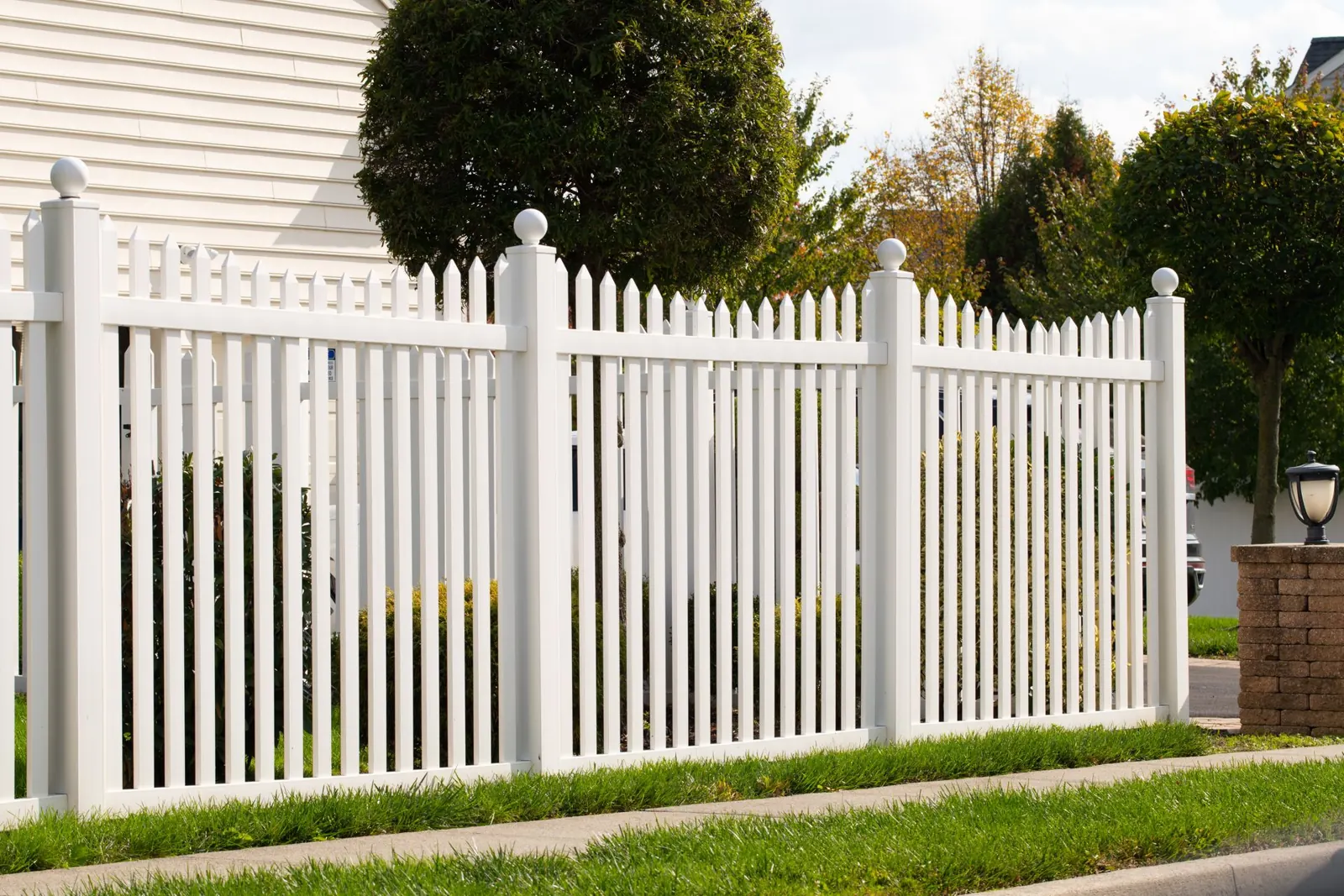 White vinyl picket fence in front of a house